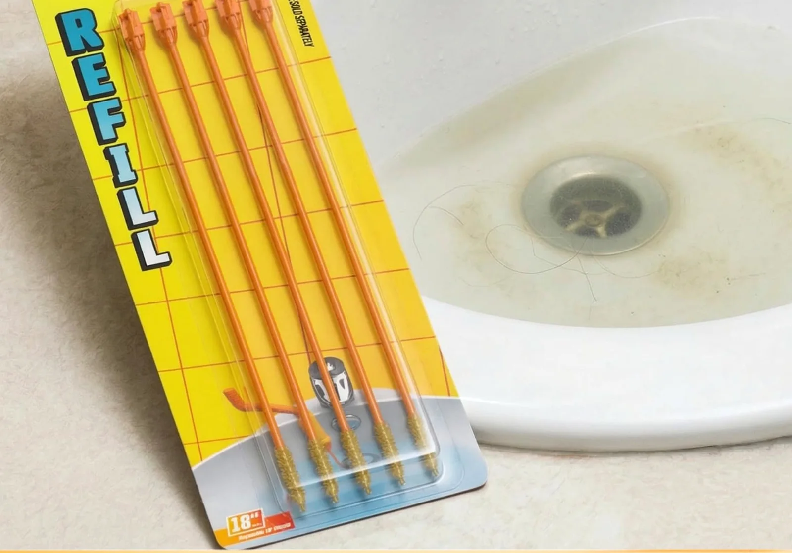A Drain Weasel refill card next to a bathroom basin